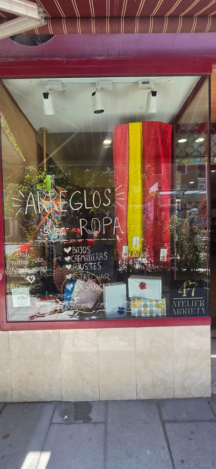 Escaparate del atelier con rotulación de arreglos de ropa
